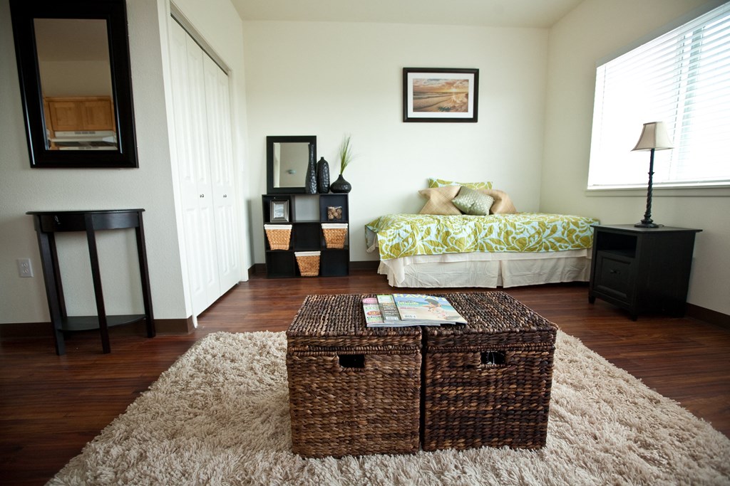a living room with a bed and a trunk in the middle