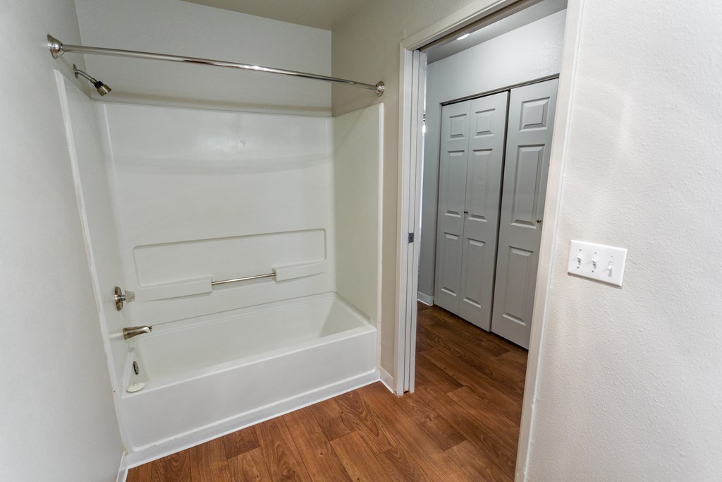 an empty bathroom with a tub and a closet