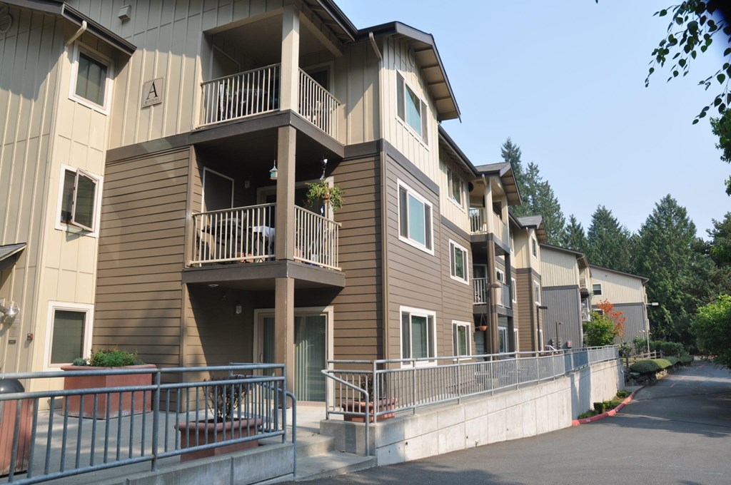 Apartment building with balconies and a metal railing.