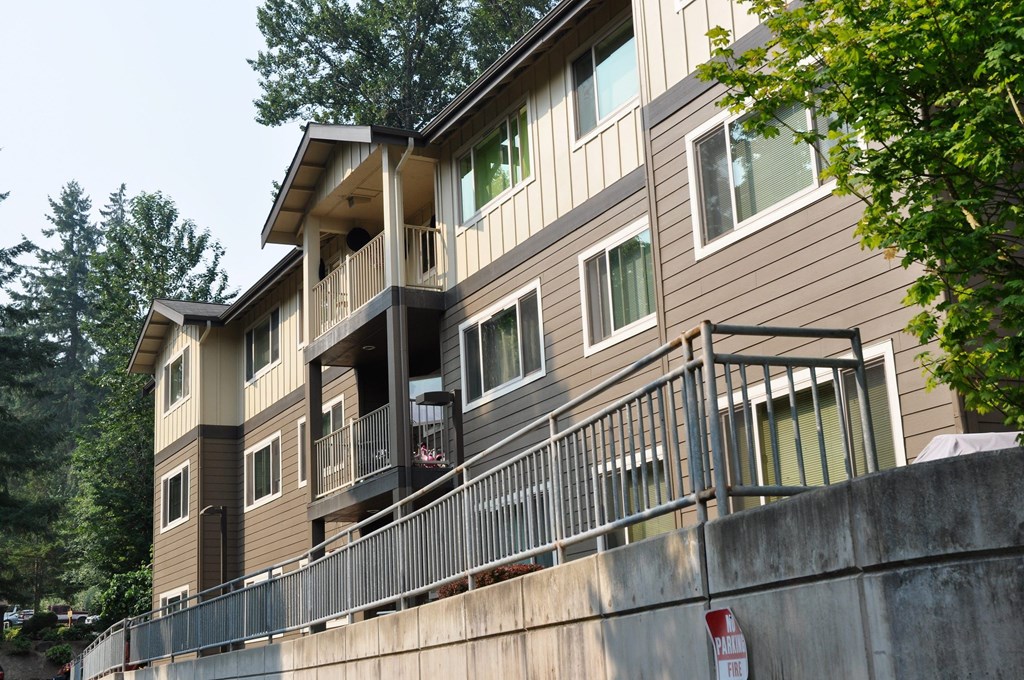 A multi-story building with a balcony and a no parking sign.