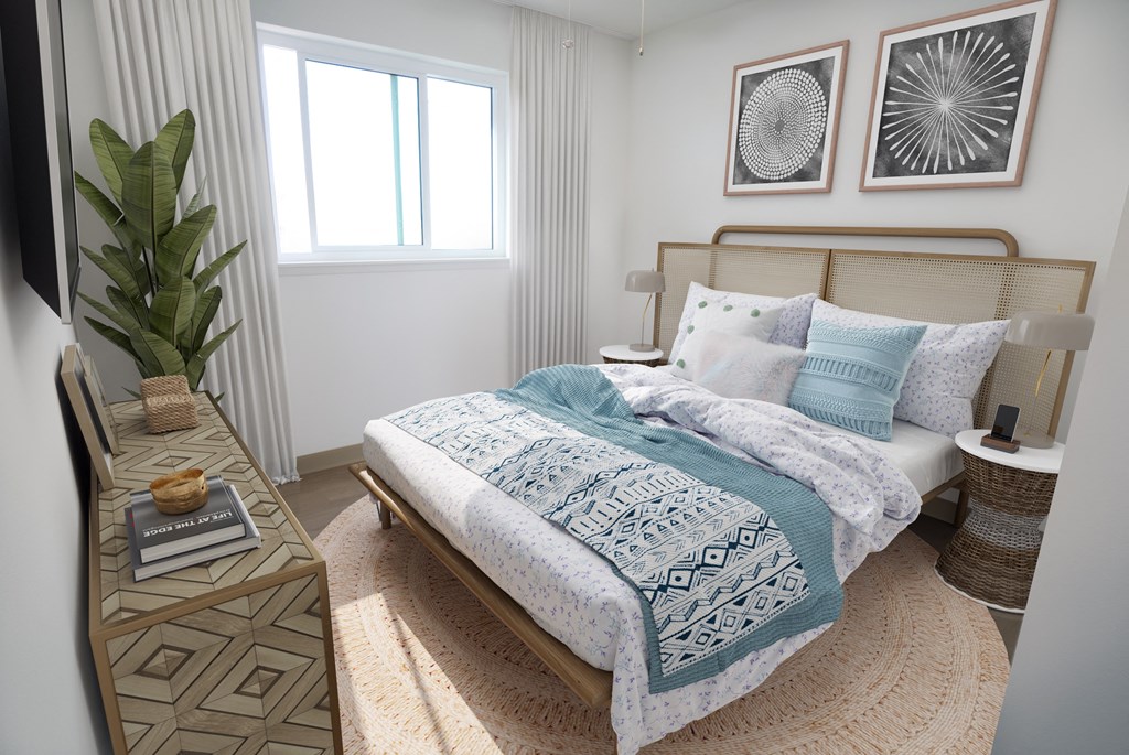 A bedroom with a bed, a nightstand, and a plant.