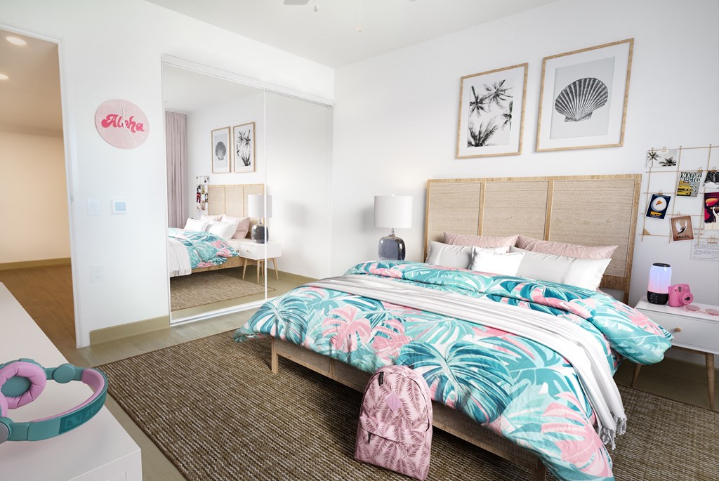 A bedroom with a bed, a nightstand, and a wall-mounted shelf with pictures and a lamp.