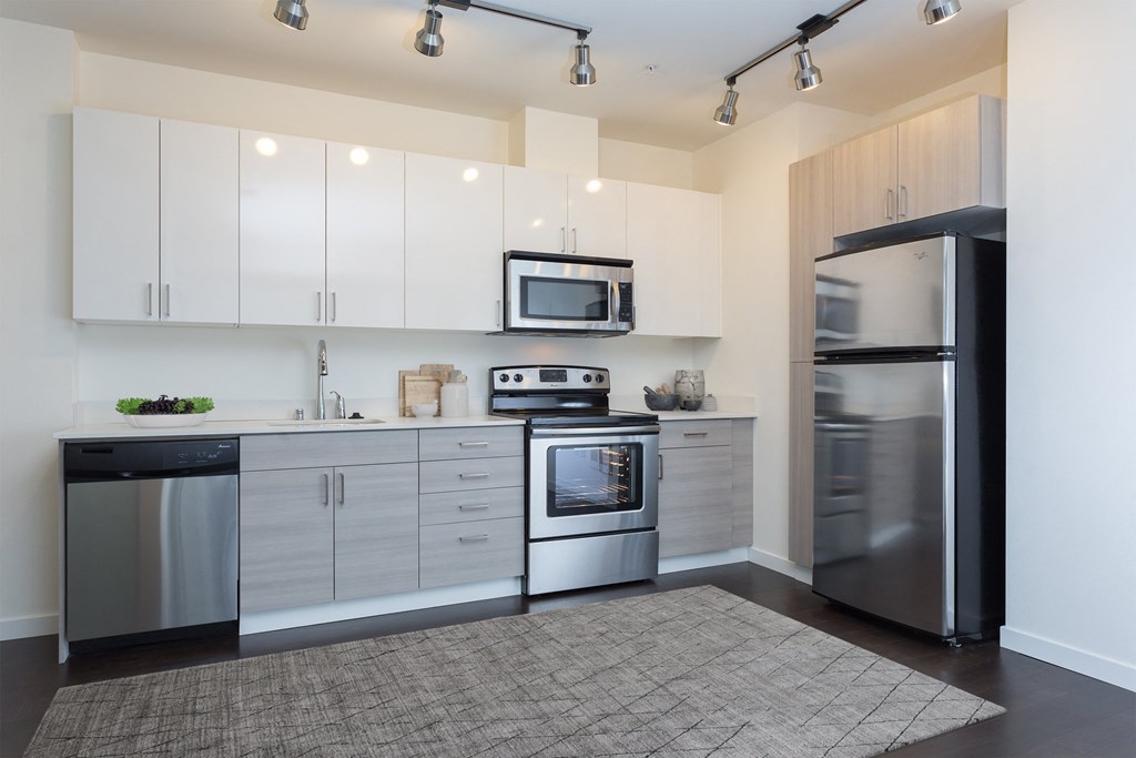 a kitchen with white cabinets and stainless steel appliances