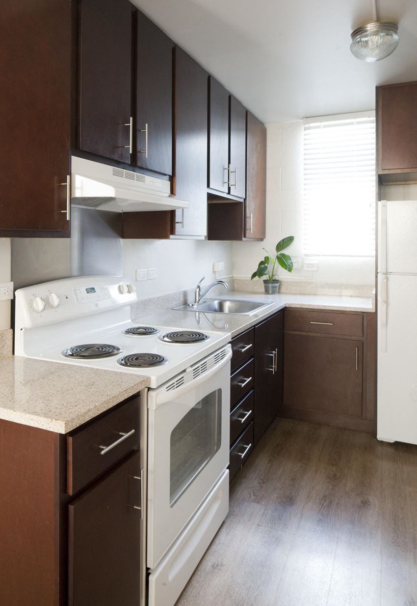 a small kitchen with white appliances and brown cabinets