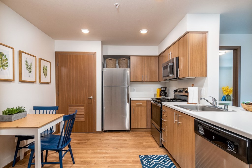 a kitchen with stainless steel appliances and a dining room table