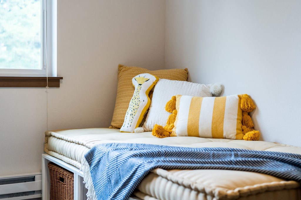 a small bedroom with a bed with pillows and a tie