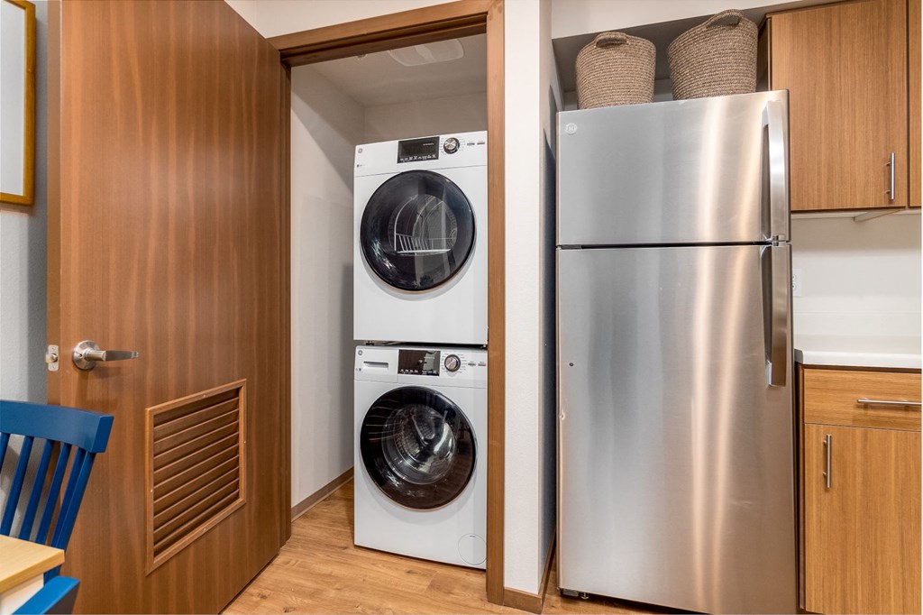 a small laundry room with a washing machine and a refrigerator