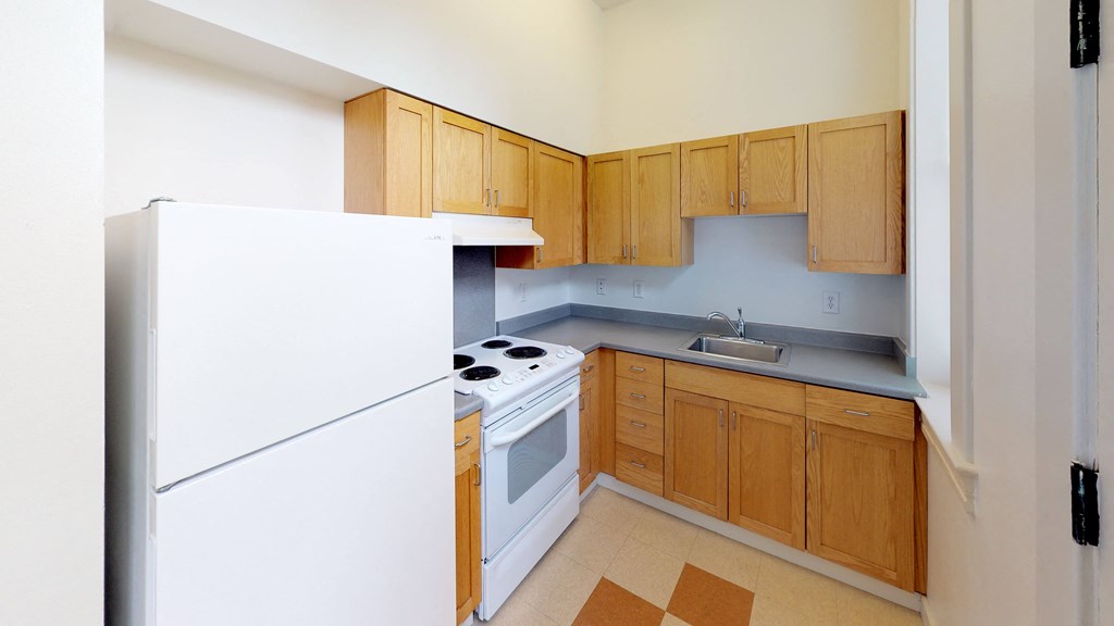 a kitchen with white appliances and wooden cabinets and a refrigerator