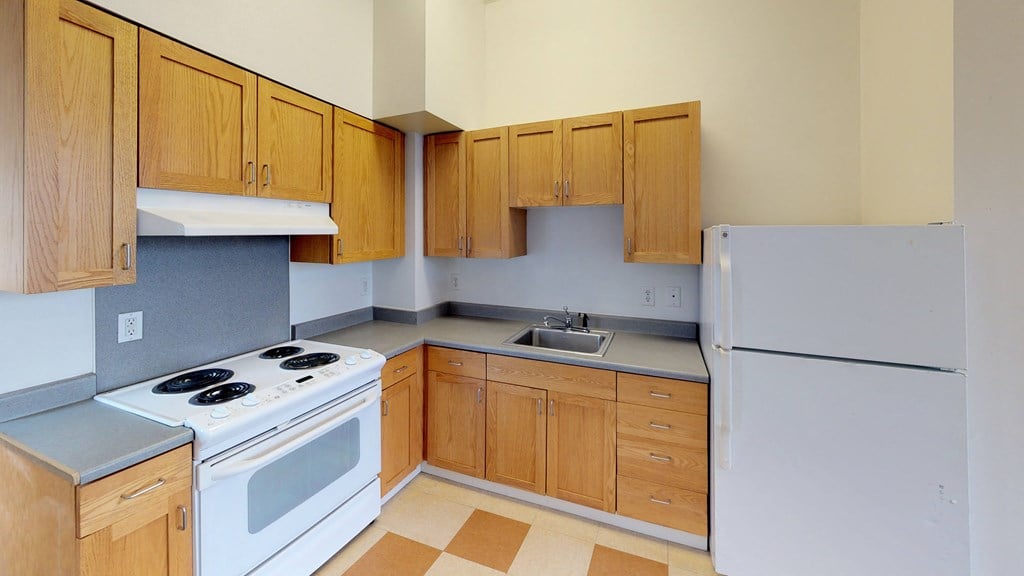 an empty kitchen with a stove refrigerator and sink