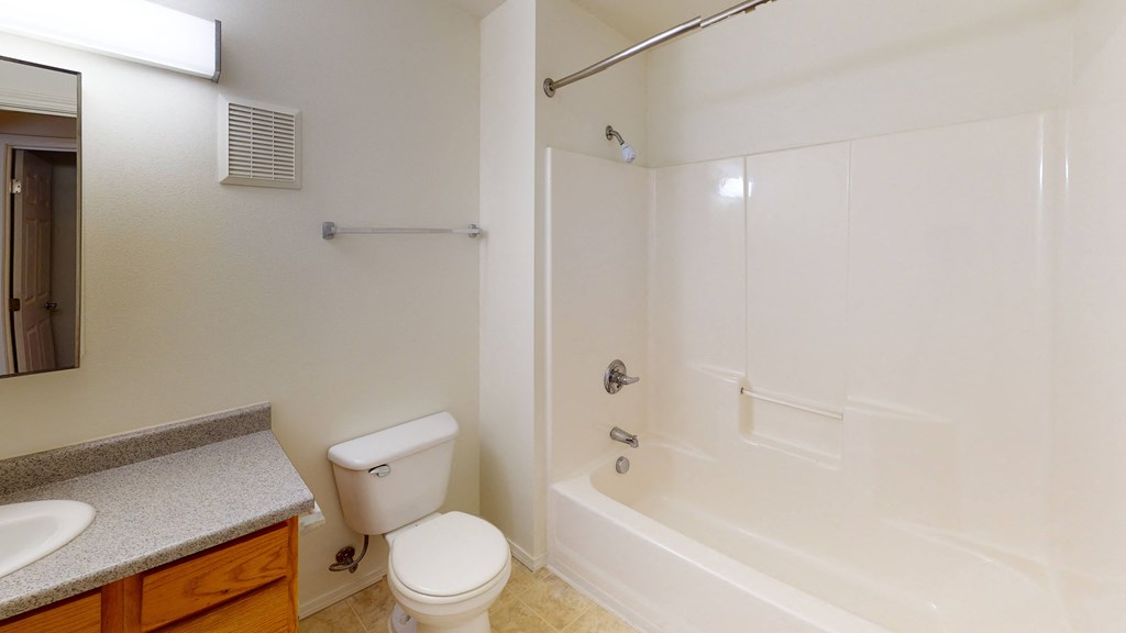 a bathroom with a shower and a toilet and a sink