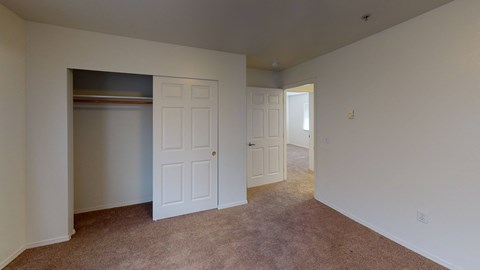 a bedroom with a closet and a door to a hallway