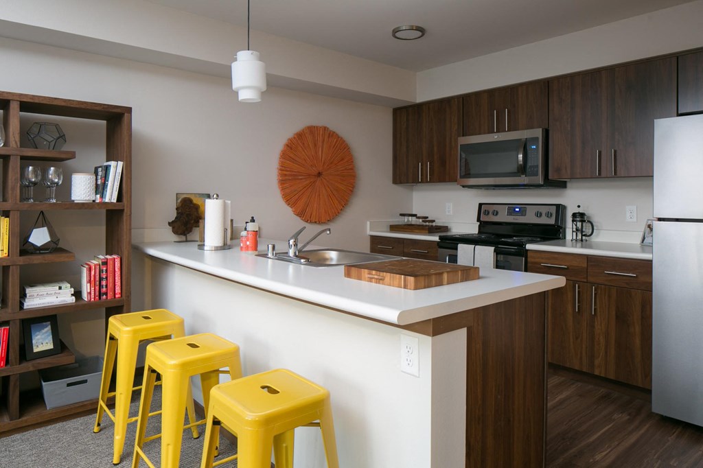 a kitchen with yellow bar stools and a counter top