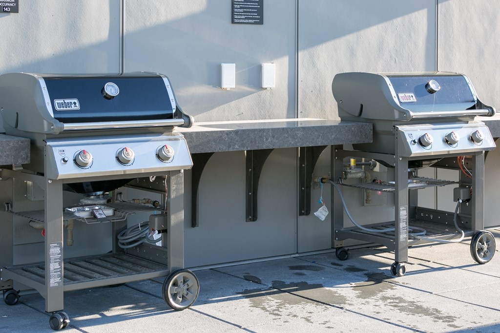 two bbq grills on the side of a building