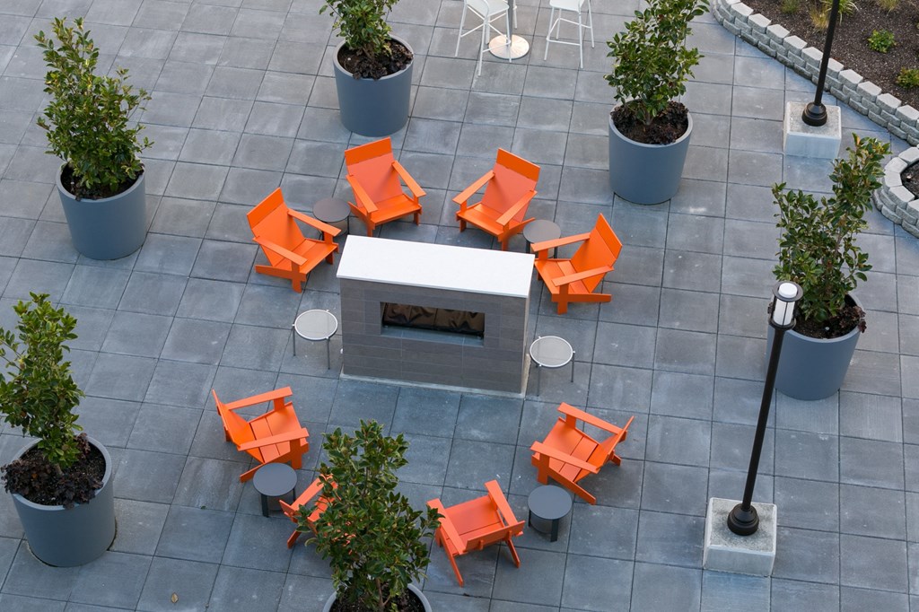 an aerial view of orange chairs around a white table in a courtyard