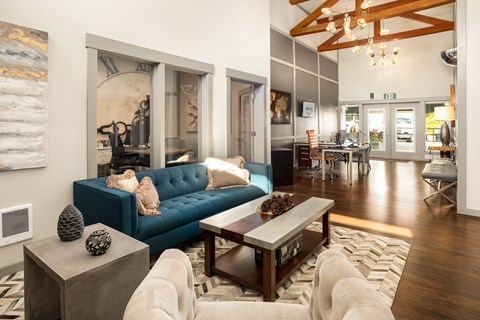 A blue couch sits in a living room with a wooden coffee table in front of it.