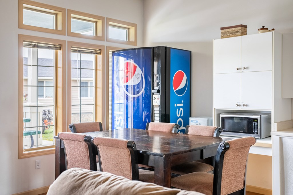 a dining room with a table and chairs and a refrigerator