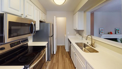 A kitchen with white cabinets and a black stove top oven.