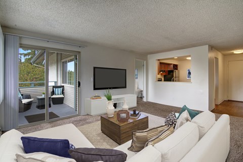 A living room with a white couch and a flat screen TV.