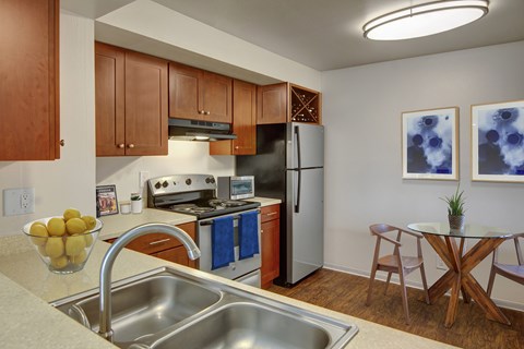 A kitchen with a stove, oven, refrigerator, and sink.