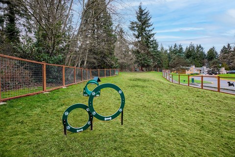 A playground with a green slide and orange fencing.