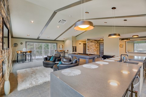 A modern kitchen with a large island and a dining area with a table and chairs.