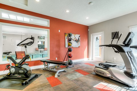 A home gym with a treadmill, elliptical trainer and a stationary bike.