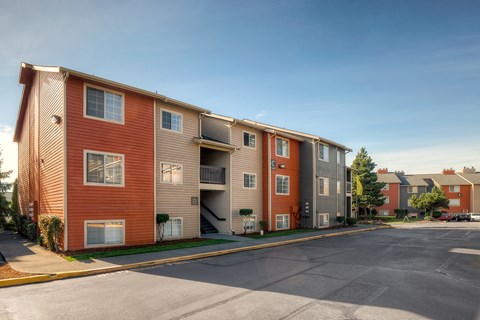 Apartment building with a parking lot in front.