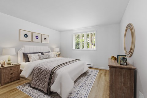 A bedroom with a large bed and a wooden nightstand.