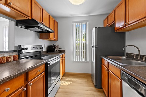 A kitchen with wooden cabinets and black appliances.