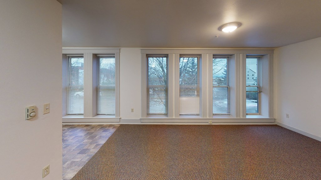 the living room of an empty house with windows