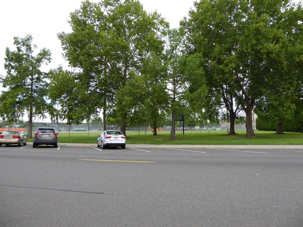 a parking lot with cars driving down the street