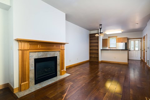 a living room with a fireplace and wooden floors
