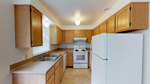 A kitchen with wooden cabinets and a white refrigerator.