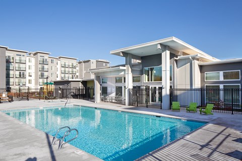 a swimming pool in front of a apartment building with a pool