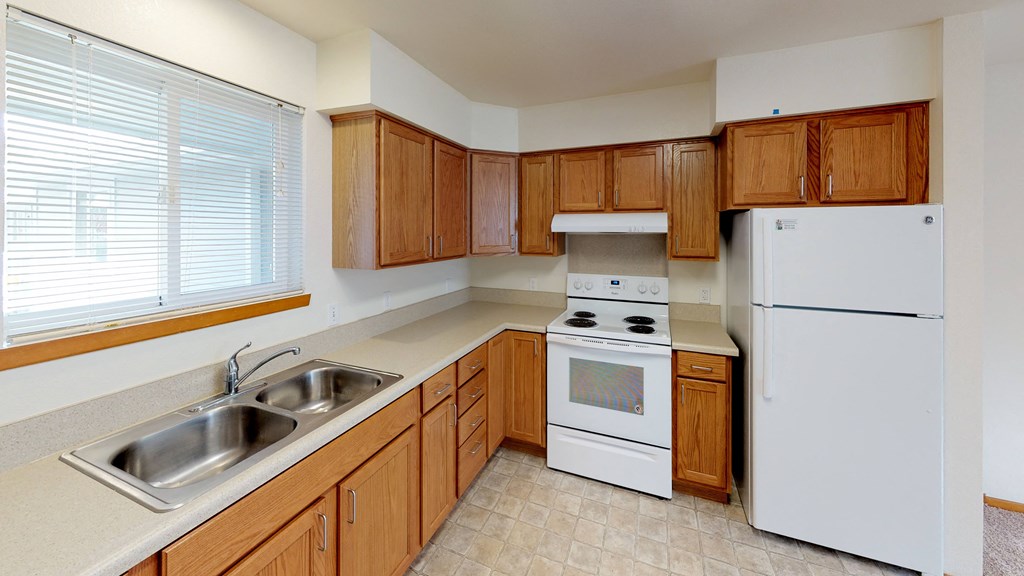 a kitchen with white appliances and wooden cabinets