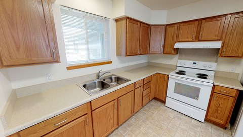 a kitchen with wooden cabinets and a sink and a stove