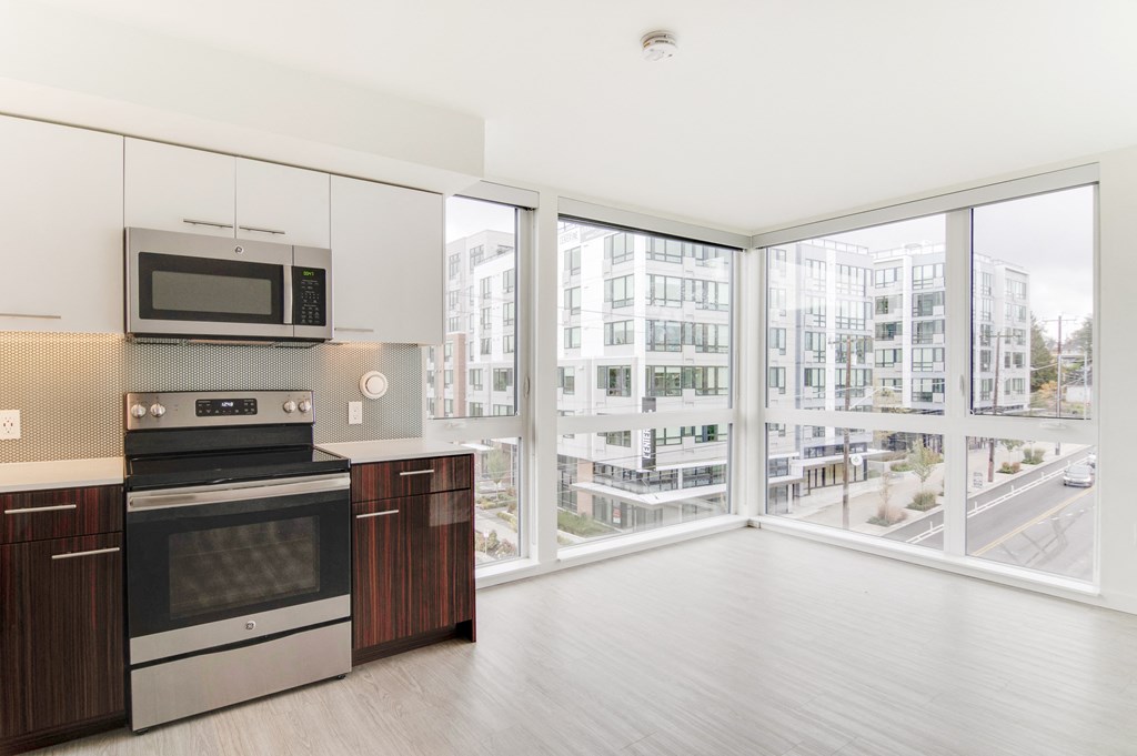 a kitchen with a large window and a stove and a microwave