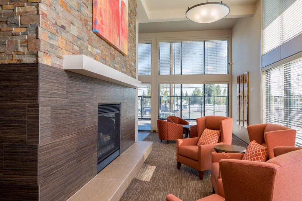 a living room with a fireplace and orange chairs