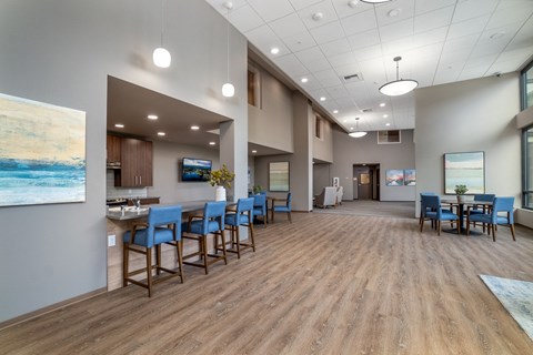 a large dining room with blue chairs and a bar and a table with chairs
