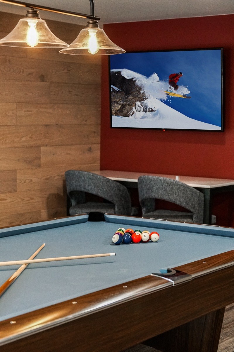 a games room with a pool table and a tv on the wall