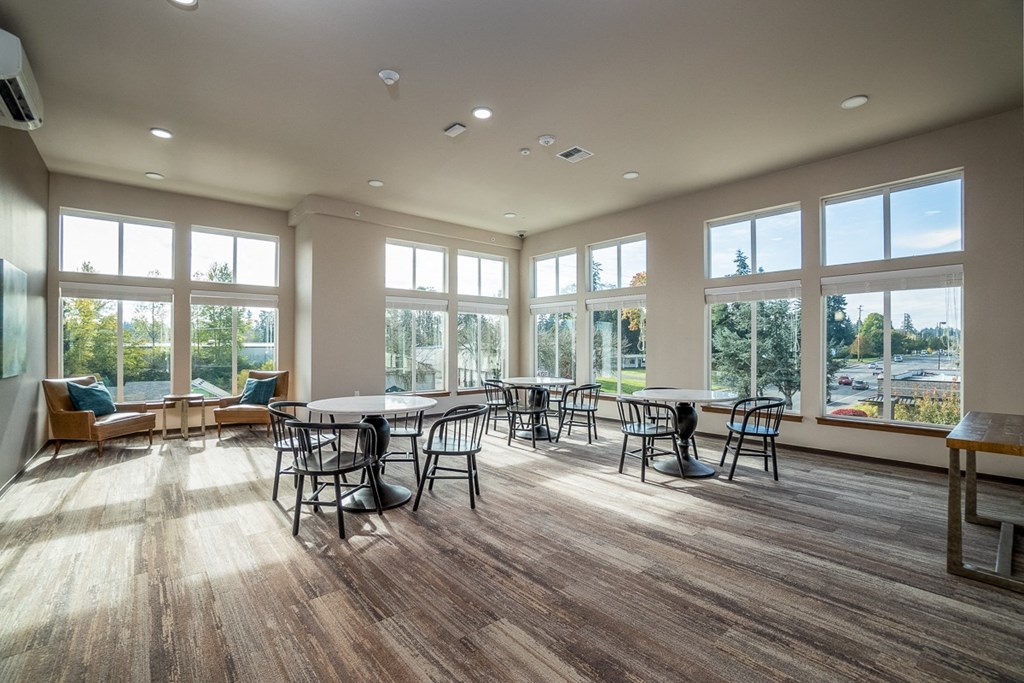 a large gathering room with tables and chairs and large windows