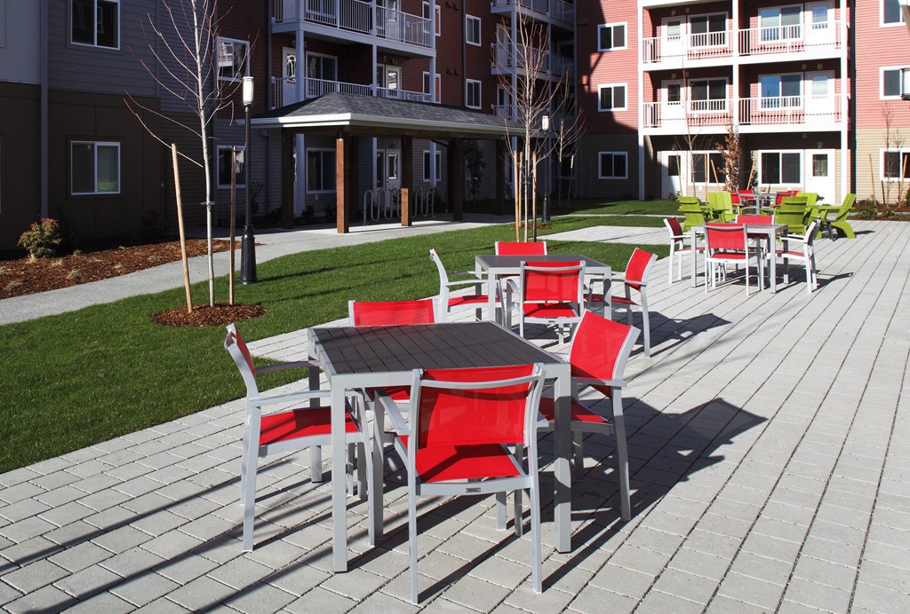 a patio with tables and chairs at an apartment complex