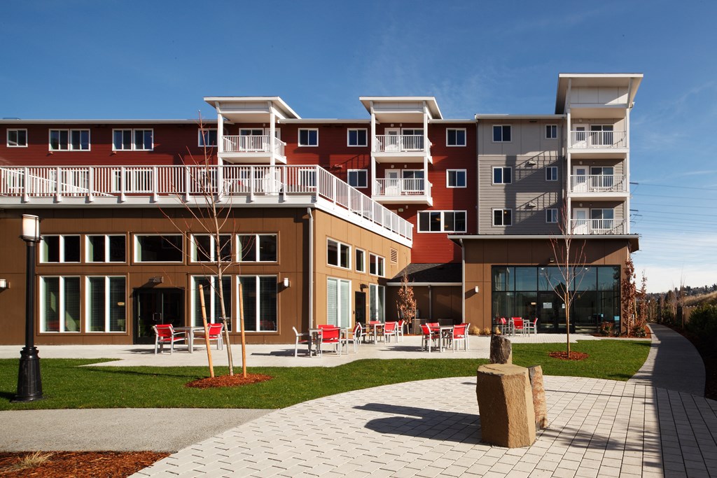 a new apartment building with red chairs in the courtyard