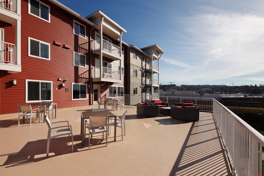an apartment building with a patio and tables and chairs