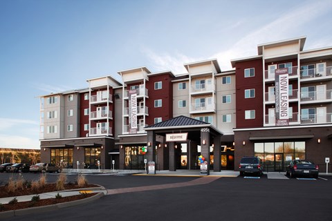 a large apartment building with cars parked in front of it