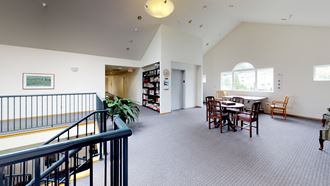 a room with a table and chairs and a staircase
