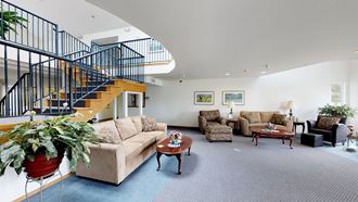 a living room with couches chairs and a staircase