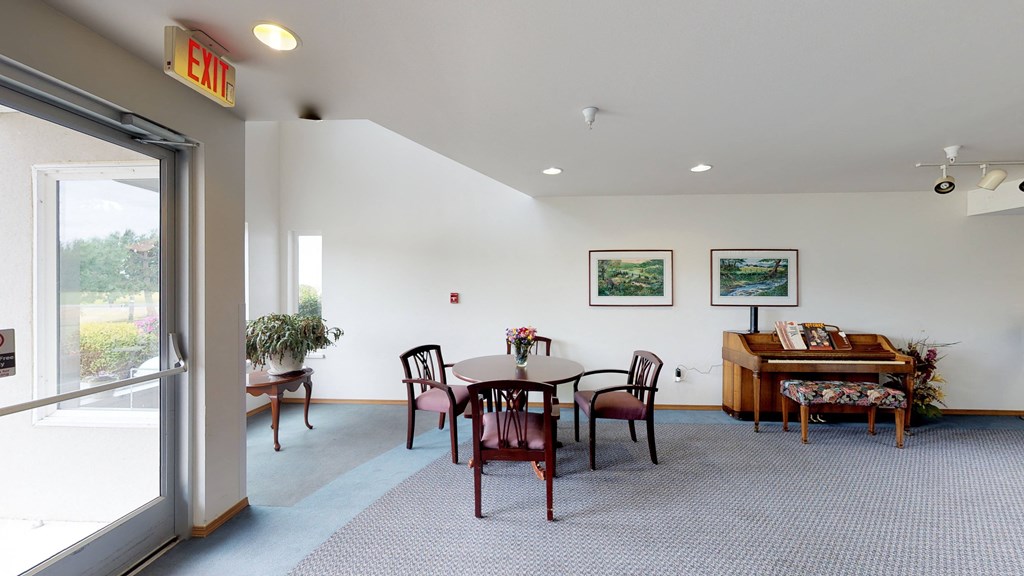 a dining room with a table and chairs and a piano