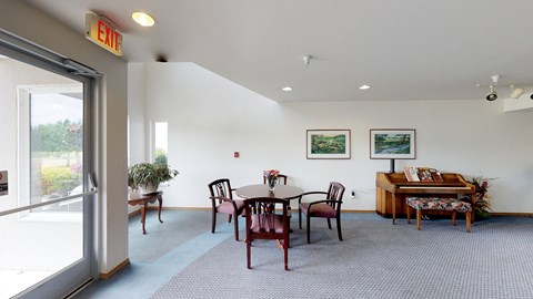 a dining room with a table and chairs and a piano