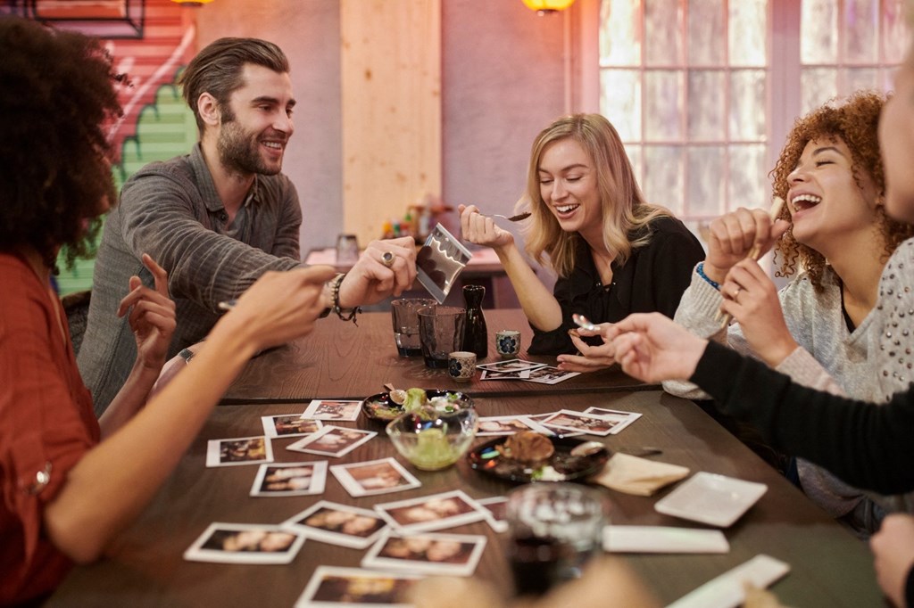 a group of people sitting around a table playing a game of monopoly